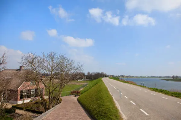 Een dijk met aan de zijkant een huis.